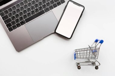 Beyaz arka planda Kara Cuma indirimi için yaratıcı promosyon kompozisyonu, sonraki dizüstü bilgisayar, market arabası, cep telefonu. Düz konum, üst görünüm, genel görünüm, model, şablon