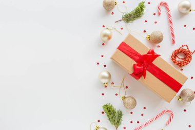 Noel kompozisyonu. Paketlenmiş hediye, beyaz arka planda duran tahta oyuncaklar. Yeni yıl konsepti. Tebrik kartı, kış tatili, kostüm kutlaması 2020. Düz konum, üst görünüm, kopyalama alanı, model, şablon