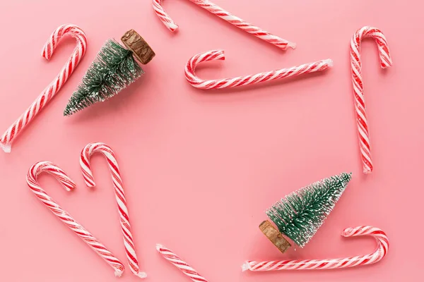 Vista superior del árbol de Navidad con muchos bastones de caramelo sobre fondo rosa pastel. Tarjeta de felicitación de celebración festiva con espacio para copiar el texto. Burla, plantilla. Concepto de Navidad, feliz año nuevo 2020 — Foto de Stock