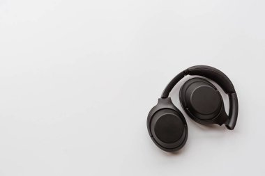 Beyaz arka planda siyah modern kablosuz kulaklıklar. Teknoloji konsepti, minimal düz yatış stili, model, şablon, üst görünüm, genel giderler