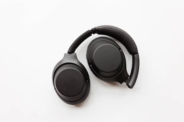 Fones de ouvido sem fio modernos pretos no fundo branco. Conceito de tecnologia, estilo flat lay mínimo, mockup, modelo, vista superior, sobrecarga — Fotografia de Stock