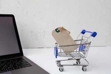 Bilgisayarlı ve market arabalı beyaz arka planda çevrimiçi alışveriş için yaratıcı promosyon kompozisyonu. maketleme, şablon