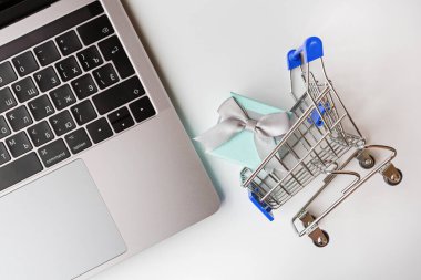 Bilgisayarlı ve market arabalı beyaz arka planda çevrimiçi alışveriş için yaratıcı promosyon kompozisyonu. Düz konum, üst görünüm, genel görünüm, model, şablon