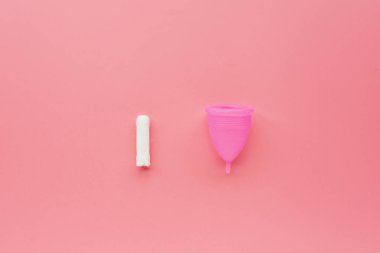Pembe arka planda regl fincanı ve tampon. O dönemde alternatif kadın hijyen ürünü. Kadın sağlığı konsepti. Uzayı kopyala Çevre dostu kavram, sıfır atık ürün. Düz yat, maket yap, templ!