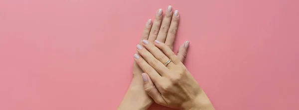 Elegante manicura rosa femenina de moda. Hermosas manos de mujer joven sobre fondo pastel rosa con lugar para el texto. Banner largo horizontal para diseño web. Concepto creativo mínimo. Puesta plana — Foto de Stock