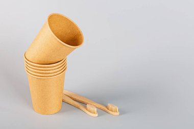 Gri arka planda ekolojik doğal kağıt bardaklar. Sürdürülebilir yaşam tarzı kavramı. sıfır atık, plastiksiz eşyalar. Plastik kirliliğini durdurun. Uzayı kopyala, şablon, Mockup. Yüksek kalite fotoğraf