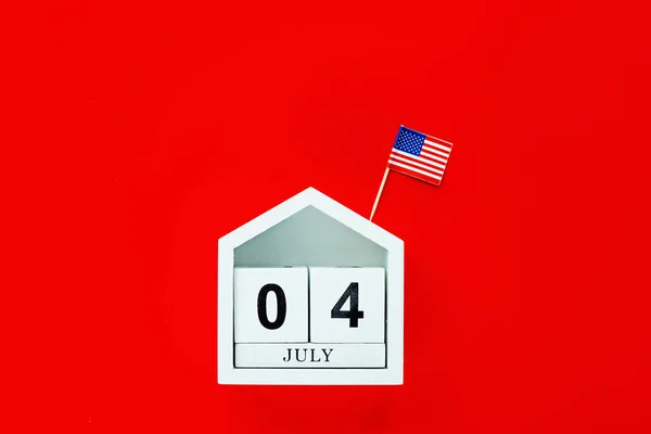 4 de julio. Burla de julio 4 calendario de color de madera sobre fondo rojo. Copia espacio para texto. Día de la Independencia de América. Plano laico, vista superior, plantilla — Foto de Stock