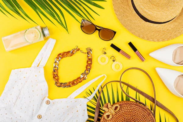 Sommarkomposition med kvinnliga modekläder. Färsk ananas, hatt, tropiska palmblad, halmhatt, bambu väska, skor på gul bakgrund. Platt låg, ovanifrån, overhead, mockup, mall — Stockfoto