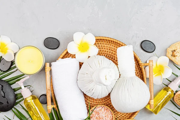 Spa massage Aromatherapy body care background. Spa herbal balls, cosmetics, towel and tropical leaves on gray concrete table. Top view, flat lay, overhead, copy space. Beauty and health care concept — Stock Photo, Image