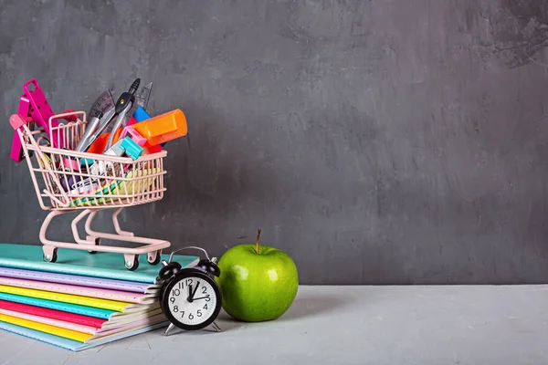 Back to School background with grocery cart. Collection of school supplies. Educational concept. Copy space, mockup, template.