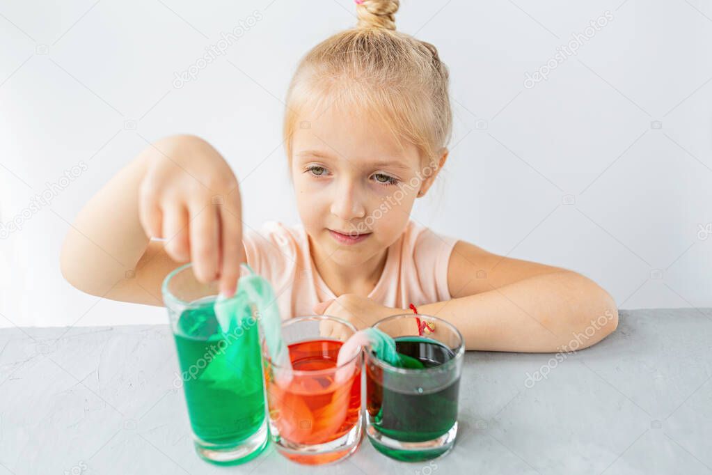 cute little girl six years old doing laboratory experiment with colorful water in classroom. Education science concept. Selective focus. Distance learning during covid-19 coronavirus quarantine. High quality photo