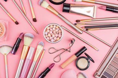 Pembe arka planda kozmetik ürünler. Düz yatış, üst görünüm