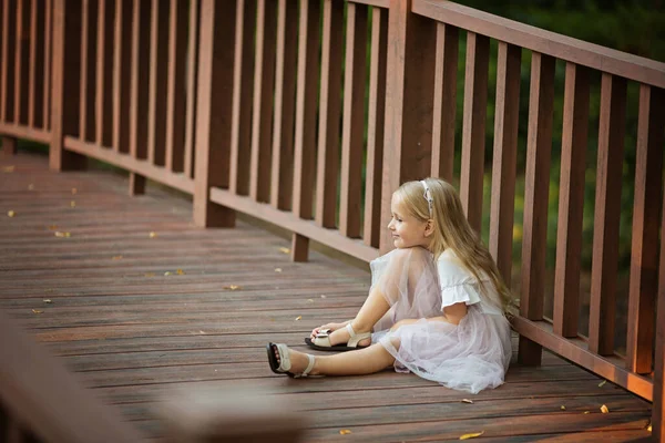 Счастливая Стильная Девочка Светлыми Волосами Сидящая Деревянном Мостике Парке Конец — стоковое фото