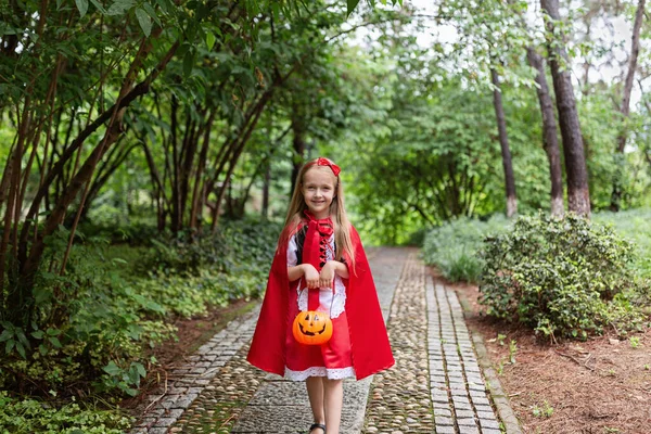 Niña con traje de sombrero rojo en el parque. Feliz concepto de Halloween —  Fotos de Stock