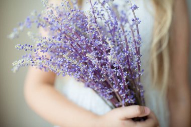 Bir buket menekşe lavanta çiçeği tutan çocuk. Anneler Günü için pankart, kadınlar için 8 Mart, spa veya güzellik salonu. Yüksek kalite fotoğraf