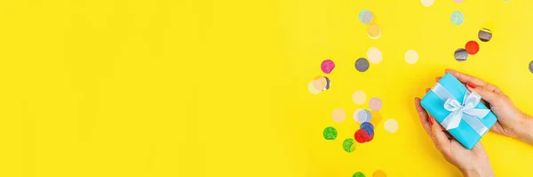 女性手持黄色背景礼品盒 顶部观景 平铺风格 生日背景 3月8日 情人节 母亲节 — 图库照片