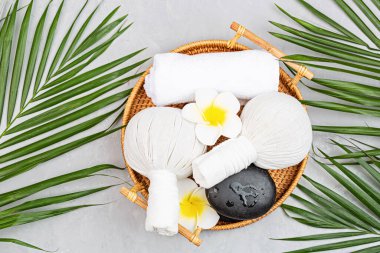 Spa masajı, vücut bakımı geçmişi. Gri taş masadaki kaplıca topları, kozmetik ürünleri, havlu ve palmiye yaprakları. Üst manzara, düz yatış, genel giderler, kopyalama alanı. Güzellik ve sağlık hizmetleri kavramı