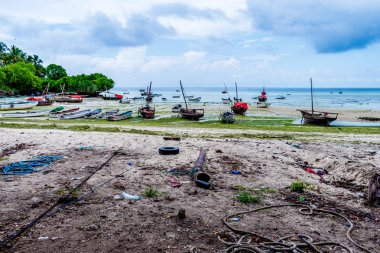 Kizimkazi Beach, Zanzibar, Tanzania, Africa - View of the fishing boats and the coast littered with garbage clipart