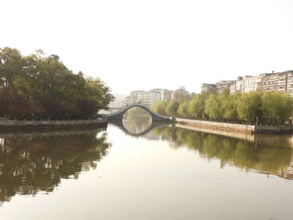 Corridor along the river and the bridge in the Chinese park