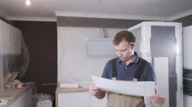 renkli tulum profesyonel handyman plastik kaplamalar ile yeni düz çizim beyaz kağıt bakar
