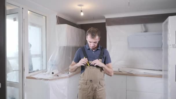 Professionell Handyman Sätter Penna Jumpsuit Bröstficka Och Veck Armar Lägenhet — Stockvideo