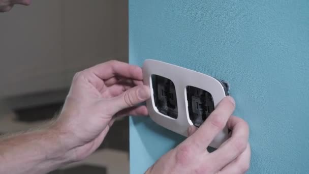 szakképzett szerelőt kezek terjed fekete switch alapon fehér kerettel kék falon a szoba közelében