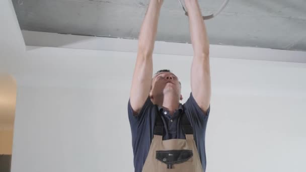 Elektrisch Specialist Grijs Shirt Lost Kabels Wit Plafond Brengt Handen — Stockvideo