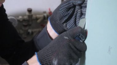 siyah pamuklu eldiven profesyonel tamirci eller metal maket bıçağı yakın görünümü ile mavi alçıpan kesim