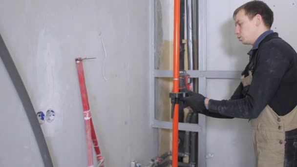 Professional Repairman Fixes Special Instrument Red Laser Light Orange Pipe — Stock Video