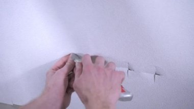 profesyonel işçi yakın çekim görüntüleri çıkış deliği üzerinde beyaz duvar kağıdı keser