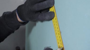 profesyonel tamirci mavi alçıpan üzerinde veri ölçer ve çizgiler çizer
