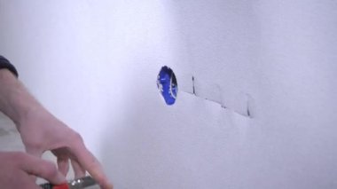 profesyonel işçi yakın çekim görüntüleri çıkış deliği üzerinde beyaz duvar kağıdı keser