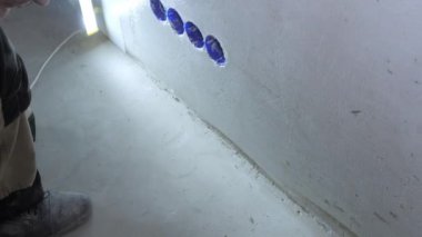 deneyimli ressam el yakın görünümünde aydınlatma lambası tutan ahşap fırça kullanarak tutkal ile çıkışları yakın duvar smear