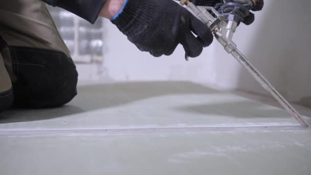 黒いダストバスターホースが付いている切られた白い乾式壁パネルのハンディマンは溝の角度を掃除する — ストック動画