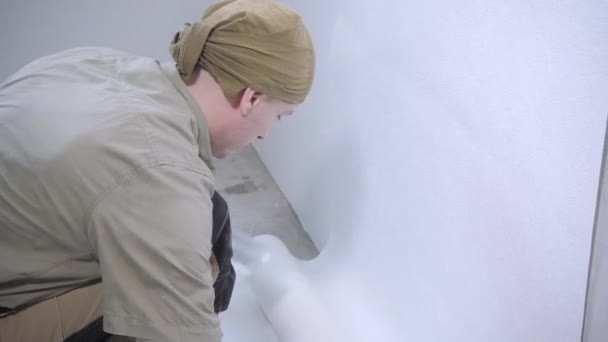 Experienced Handyman Brown Jumpsuit Bandana Hangs White Wallpaper Floor Holding — Stock Video