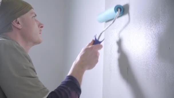 Focused Handyman Brown Jumpsuit Black Pullover Runs Blue Glue Roller — Stock Video