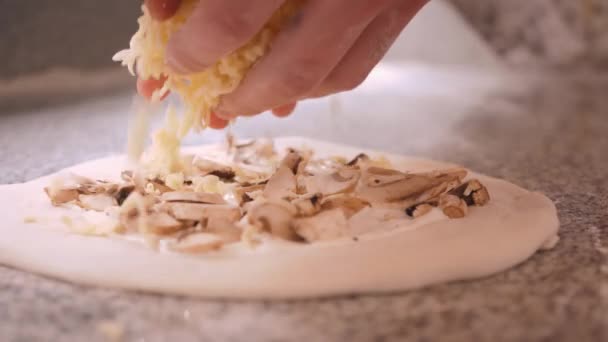 Pizza kavárna šéfkuchař sype strouhaným sýrem na syrové houby — Stock video