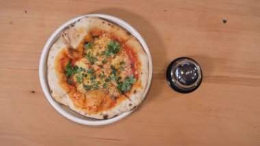 Pizzacı mutfak masasından mis kokulu bir tabak alır.