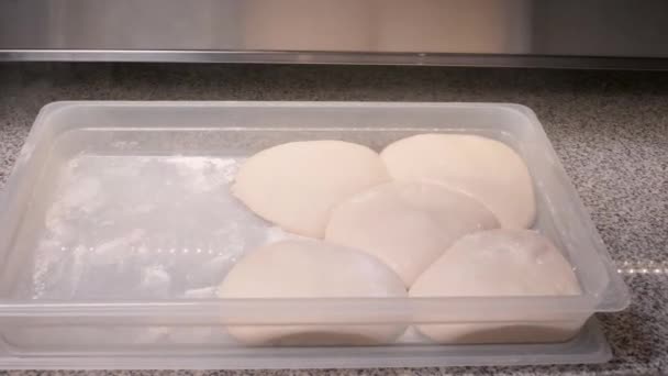 Chef espolvorea harina sobre la masa y saca de la caja de plástico — Vídeo de stock