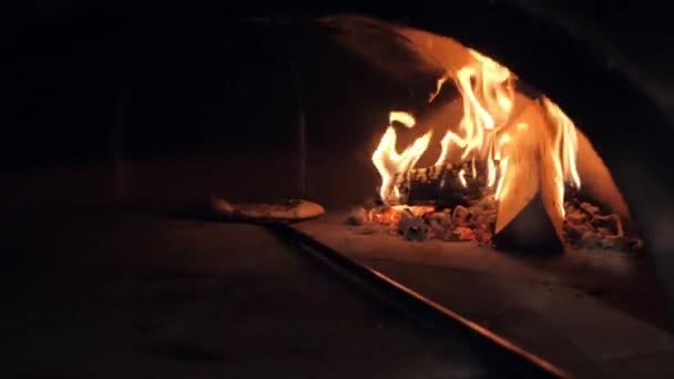 Trabajador auxiliar cafetería sostiene pizza italiana cerca de llama ardiente — Vídeo de stock