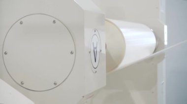 Otomatik makine atölyede yapışkan bant rulosunu döndürür