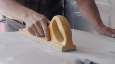 teknisyen otomobil gövdesi parçasını cilalamak için manuel araç kullanır