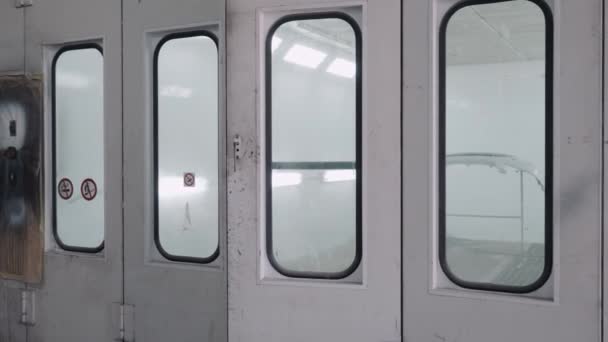 Trabalhador entra na sala para pintar o corpo do carro com escova de ar — Vídeo de Stock