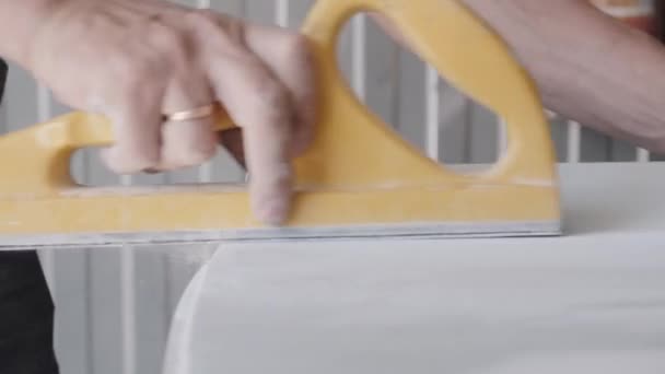 Працівник полірує деталі автомобільного кузова в легкій майстерні — стокове відео