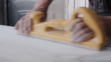 Erkek işçi otomobil vücut yüzeyini araçla cilalıyor