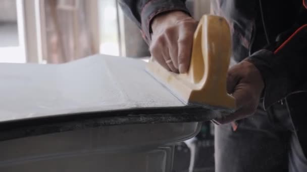 Άνθρωπος γυαλίζει αυτοκίνητο μέρος του σώματος με χειροκίνητο εργαλείο στη σκόνη — Αρχείο Βίντεο