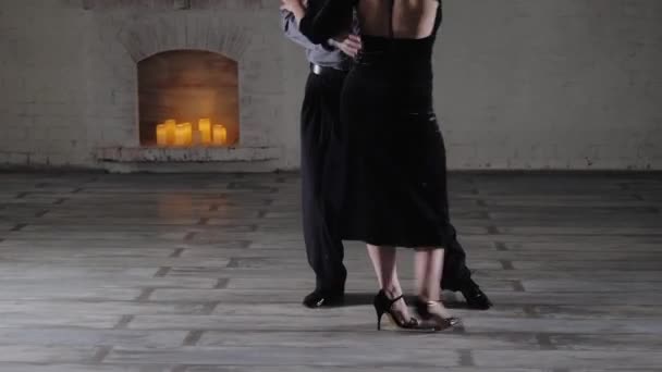 Man en vrouw dansen Argentijnse tango tegen open haard — Stockvideo