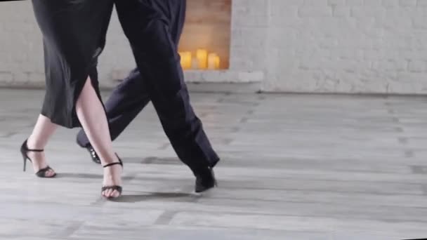 Woman in black dress with man dances tango in light studio — Stock Video