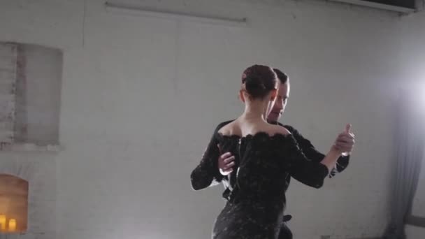 Paar in eleganter Kleidung tanzt argentinischen Tango bei Licht — Stockvideo