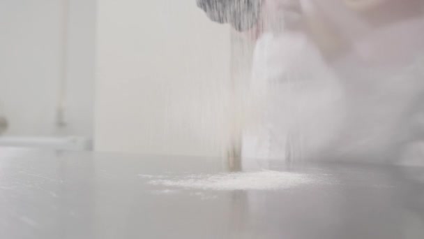 Людина п'є біле борошно на столі, щоб приготувати смачну випічку — стокове відео